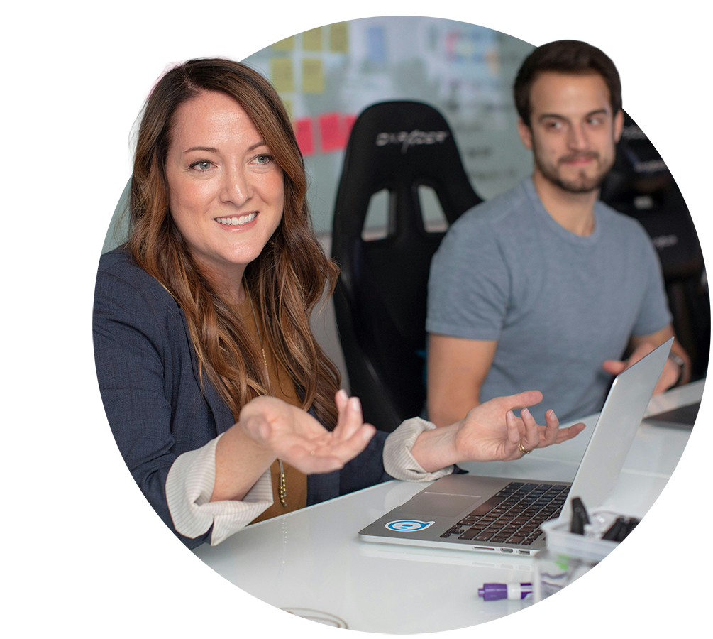 Colleagues discussing a course in front of a laptop